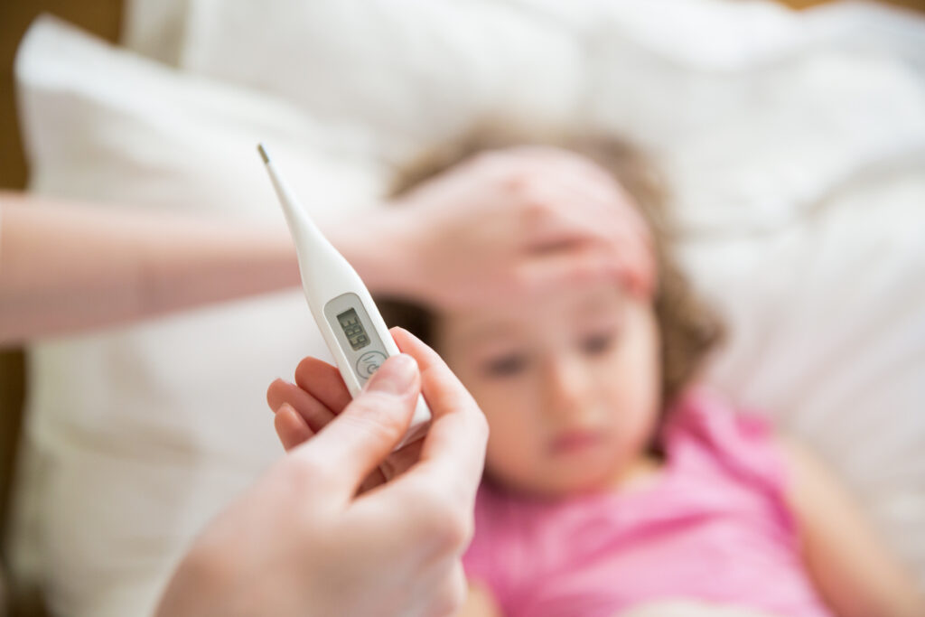 Close-up thermometer. Mother measuring temperature of her ill k