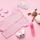 Baby clothes and accessories on color background