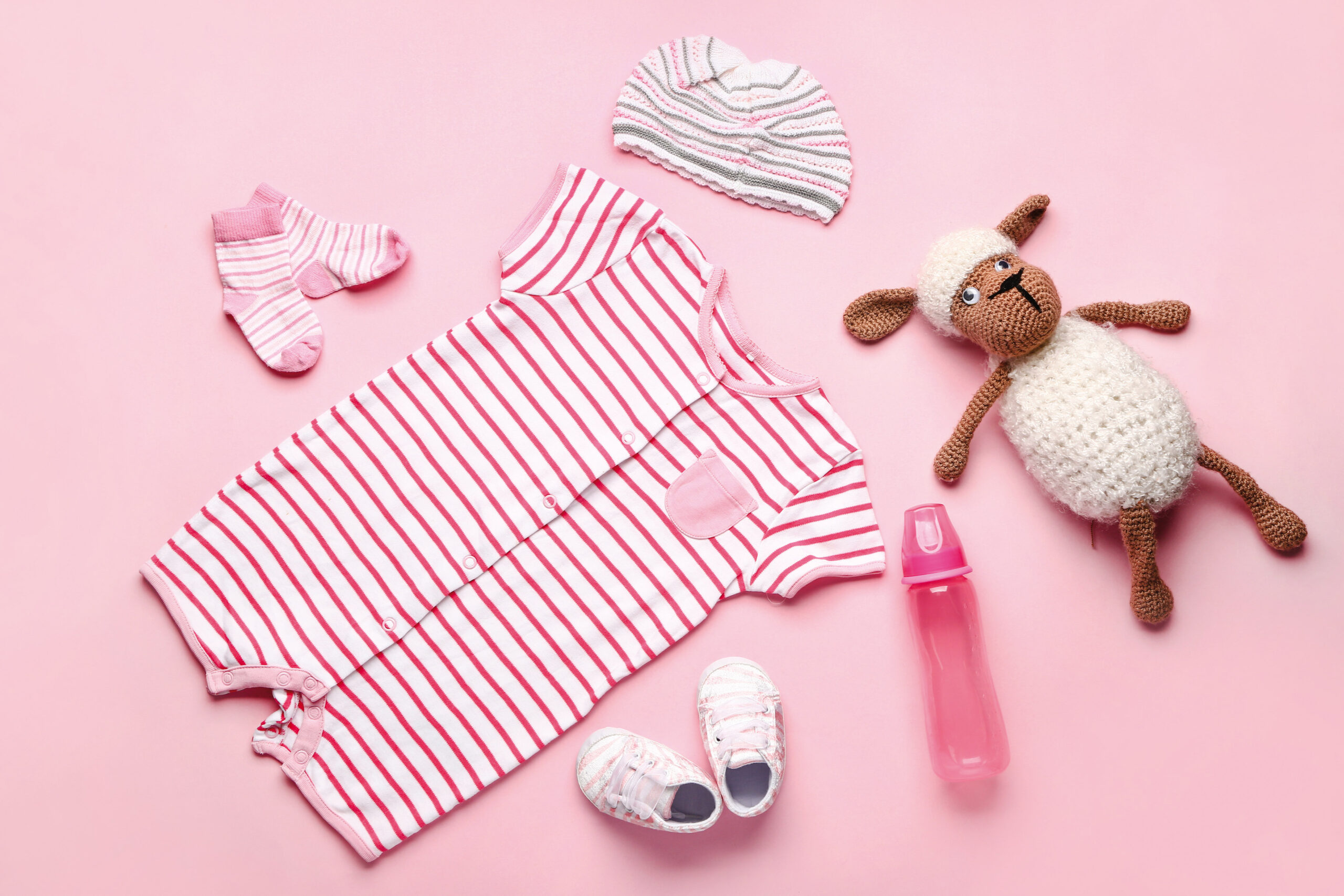 Baby clothes and accessories on color background