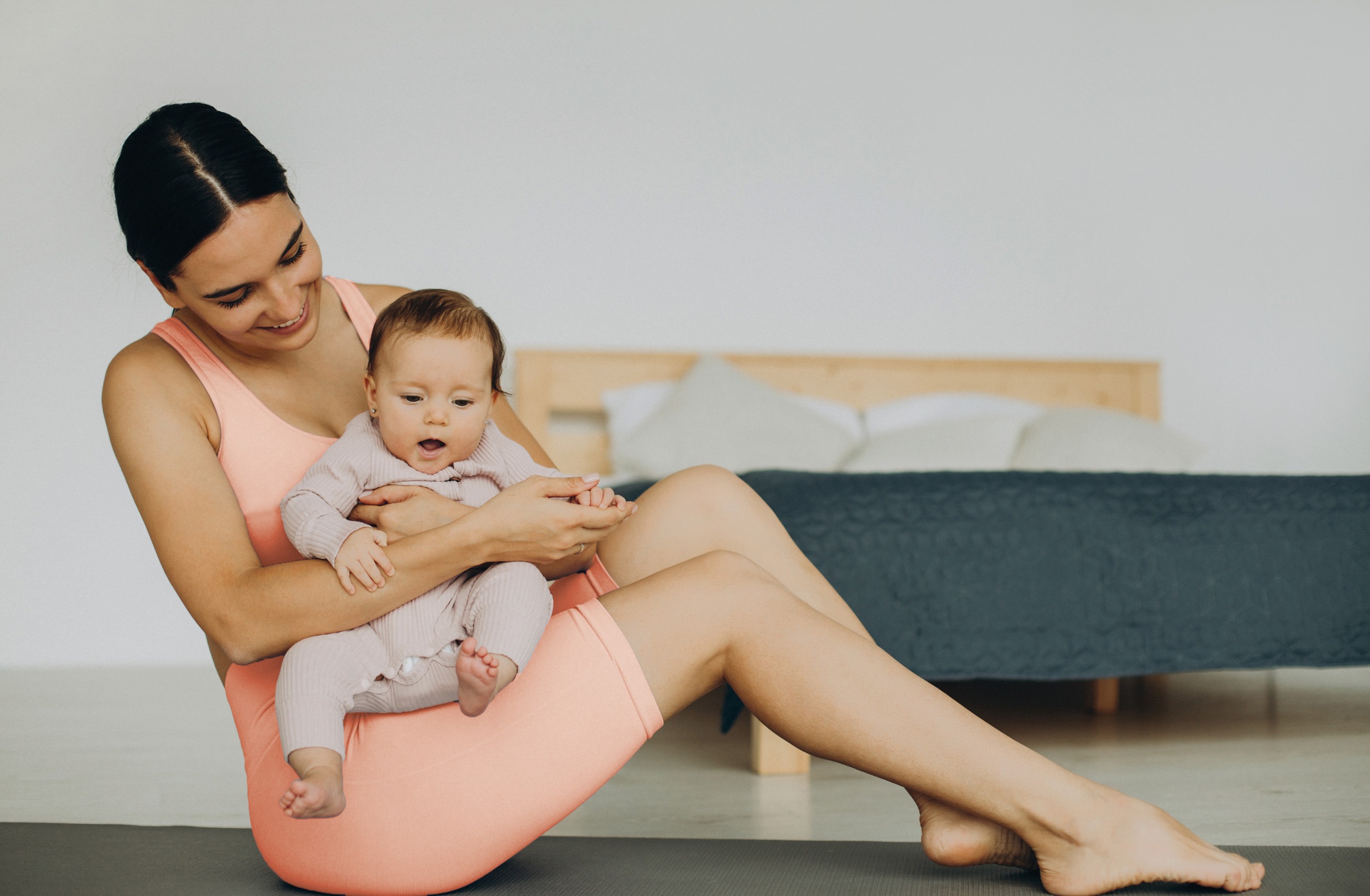 Mother with her baby daughter practice yoga at home