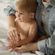 Mother_applying cream_onto_her_baby's_body_on_bed_at_home,_closeup